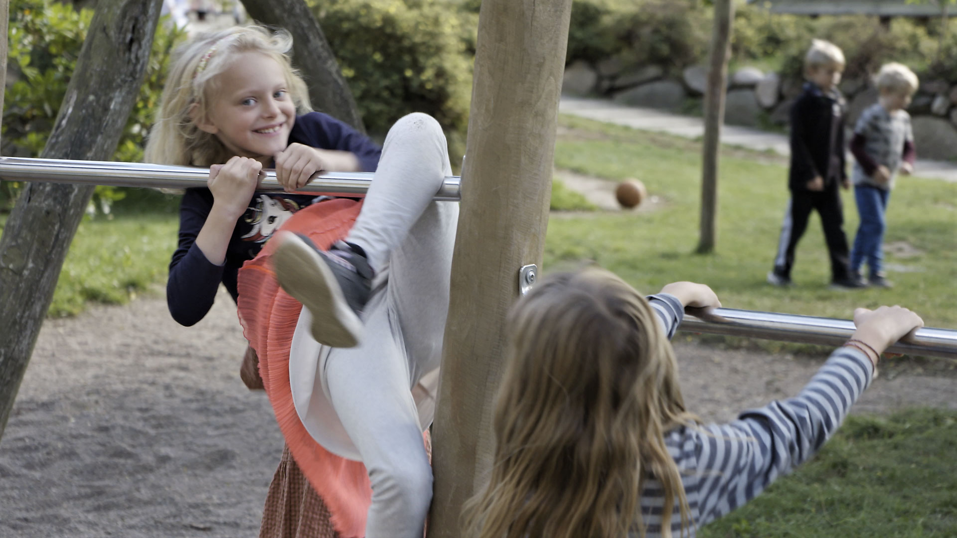 2 piger snakker med en lærer på skolegangen