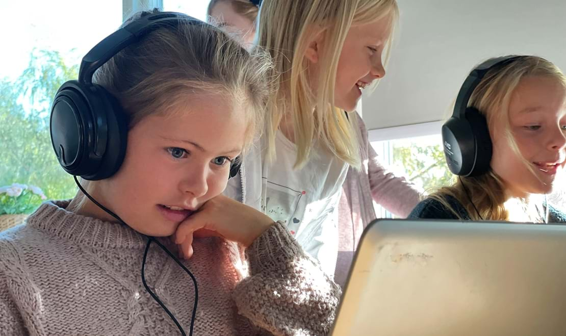 Billede af elever der lytter til musik på computere